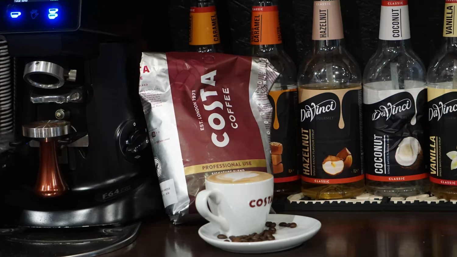 espresso machine, a large coffee bag and a cup of coffee